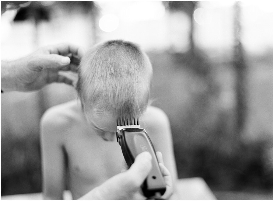 Boy getting hair shaved with clippers.